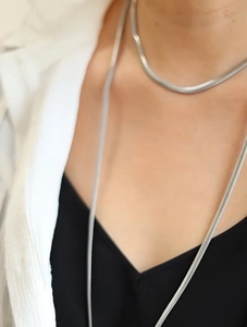 Detailed layered look of silver snake bone chains in long and short lengths on model