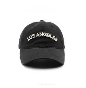 Detailed close-up of white 3D Los Angeles embroidery on a black cotton baseball cap