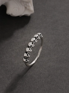 Dettaglio anello teschio gotico d'argento con finitura vintage su fondo scuro