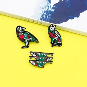 Artistic animal skeleton enamel pins with crow cat and fish motifs on yellow background
