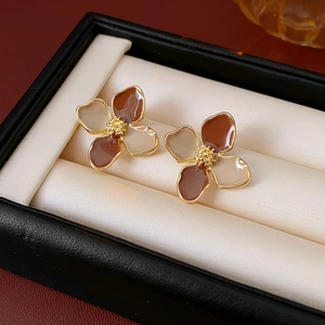 Detailed view of vintage flower earrings with brown and beige enamel in a luxury jewelry box