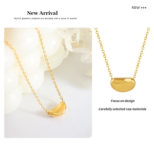 Macro detail of golden bean pendant necklace featuring high-polished metallic finish