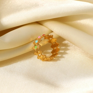 Detailed close-up of 18K gold-plated crown ring with colorful enamel on beige silk