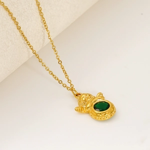 Detailed close-up of a golden Cupid angel pendant necklace with a green faceted gemstone