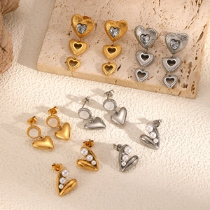 Luxe heart-shaped stainless steel earrings with sparkling diamonds and pearls displayed