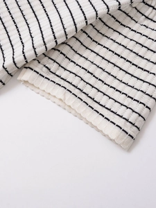 Détail du tissu en maille côtelée à rayures noires et blanches avec ourlet de manche bord-côte
