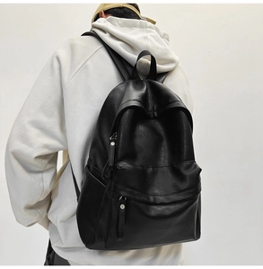 Minimalist black PU leather backpack worn by a model against a neutral studio background