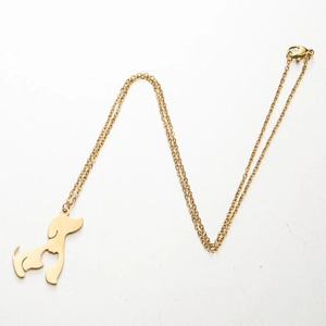 Close-up of golden stainless steel dog pendant with lobster clasp on a thin chain