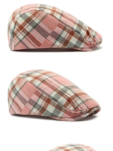 Detail of pink and grey plaid newsboy cap showing textured fabric and stitching