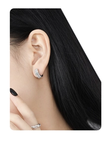 Close-up of S925 sterling silver hoop earrings with pavé zircons worn by a model