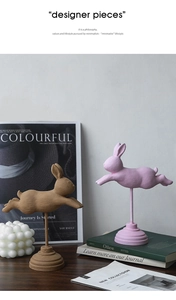 Statuine di coniglio in marrone e rosa su scrivania in legno con dettagli decorativi moderni