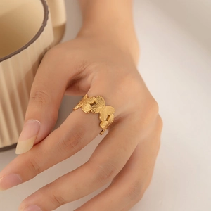 Close-up of golden butterfly ring featuring brushed metal texture on adjustable band