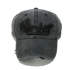 Close-up of NEW YORK embroidery and distressed holes on washed cotton baseball cap