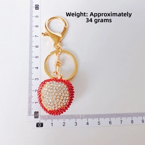 Detail shot of sparkling red rhinestone heart keychain with gold horse eye buckle