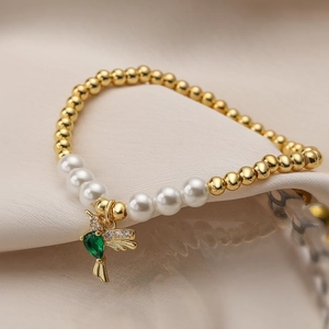 Elegant white pearl and gold bead elastic bracelet featuring a green bird pendant