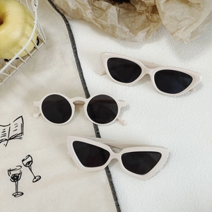 Retro cream cat-eye and round sunglasses for women on artistic lifestyle background