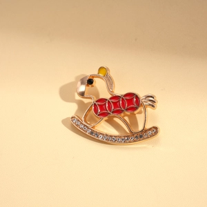 Macro detail of cartoon rocking horse brooch with red enamel and sparkling rhinestones