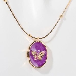 Detail der goldenen Medaillon-Kette mit lila Emaille und feinem Schmetterlingsmuster