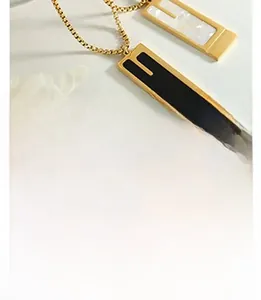 Detailed macro view of gold-tone rectangular necklaces with black and white pearl inlays