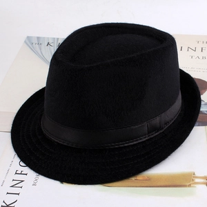 Vue de dessus d'un chapeau fedora en laine noire sur un fond de magazine minimaliste