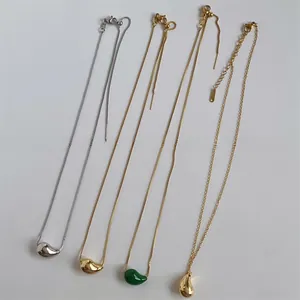 Detail of water drop pendants in gold and silver finishes with polished metal surface