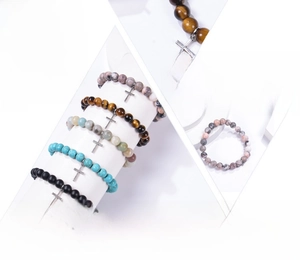 Detail showing 8mm natural stone beads with silver cross charm on stretch bracelets