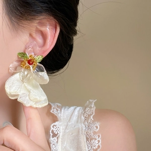 Eleganti orecchini a fiore in tessuto fatti a mano indossati da una modella con stile