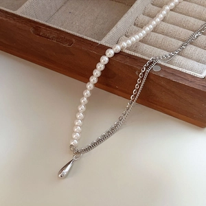 Elegant 925 sterling silver necklace with white pearls and a teardrop pendant on wood