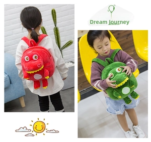 Detail of red and green plush dinosaur backpacks showing 3D texture and fabric straps