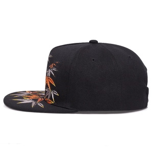 Close-up of dense bamboo leaf embroidery on a black flat brim hip-hop snapback hat