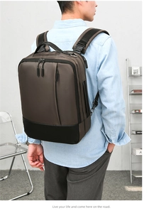 Rear view of a business laptop backpack on a model showing back straps and D-rings