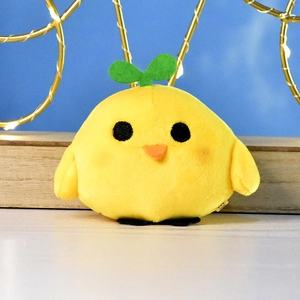 Close-up of a yellow plush chick with a green sprout on its head and soft fur texture.