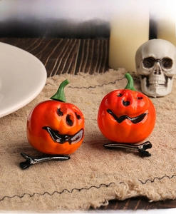 Detail of Halloween pumpkin hair clips with funny faces on rustic burlap background