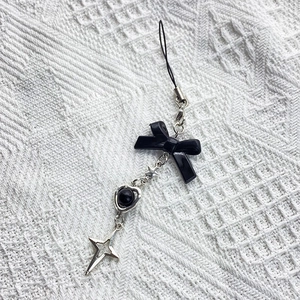 Sweet-cool Y2K black resin bow and silver star phone chain charm on white lace