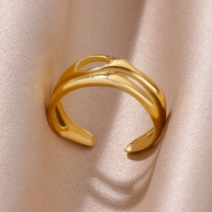 Detailed shot of gold-plated stainless steel hollow interwoven adjustable ring on silk