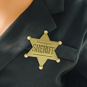 Vintage metal six-pointed star Sheriff badge brooch pinned on a black suit lapel