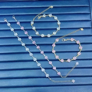 Detailed view of silver and gold heart-shaped gemstone bracelets with zircon inlays