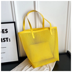 Close-up of bright yellow mesh beach tote with reinforced top handles and PU trim