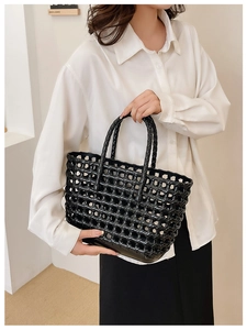 Detail of black woven jelly tote bag with glossy finish and sturdy carry handles