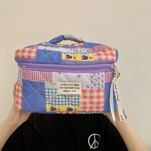 Detail of quilted patchwork makeup bag with floral patterns and a white textile label