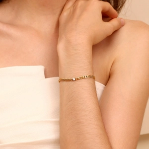 Close-up of elegant 18K gold plated chain bracelet with a single round zircon on wrist