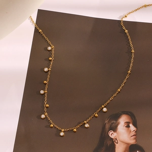 Gros plan du collier plaqué or 18 carats avec pendentifs en zircone et détails de perles