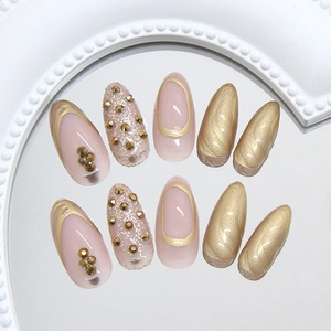 Sparkling champagne gold and light pink press-on nails with 3D rhinestones and glitter