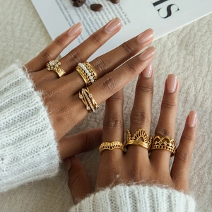 Lifestyle shot of gold-plated rings with pearls and zircon on woman's hand with coffee beans