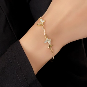 Detail of a gold-plated butterfly bracelet with zircons and mother of pearl on a wrist