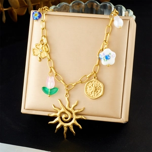 Detail of vintage gold plated stainless steel chain necklace with sun and heart charms