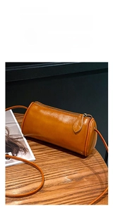 Detailed view of the stylish brown cylindrical leather shoulder bag, highlighting soft texture.