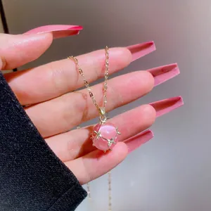 Nahaufnahme von rosa Katzenaugen-Anhänger mit Goldsternhalterung und feiner Kette