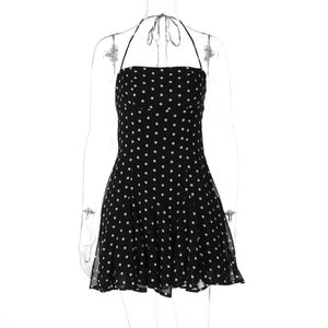 Detail shot of black halter neck dress with white polka dot pattern and lightweight fabric