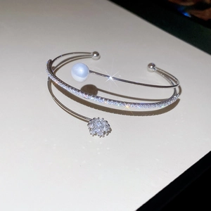 Detail of silver pearl bracelet with floral zircon accents and adjustable triple-layer band